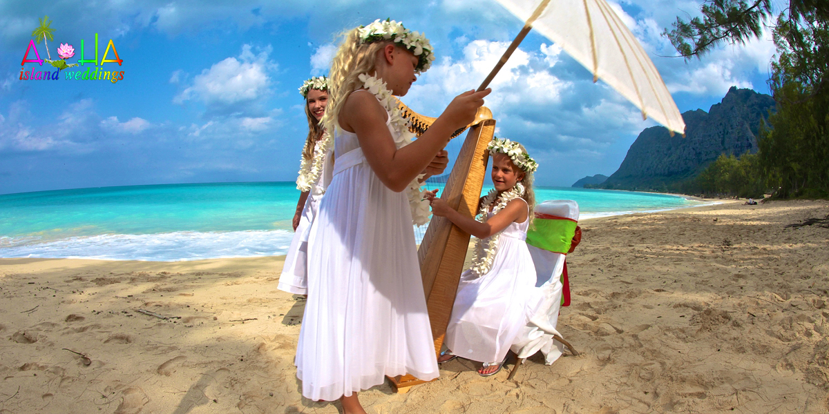 flower girls at thier moms beach wedding in Hawaii play the harp